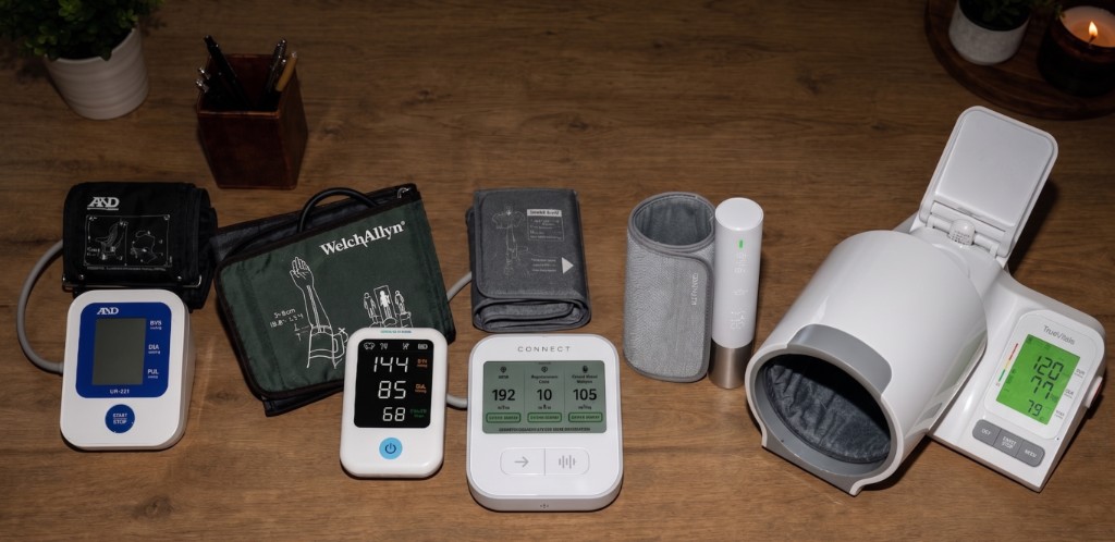 Five blood pressure monitors tested side by side on a table